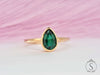 Pear cut green emerald solitaire bezel ring front view