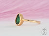 Pear cut green emerald solitaire bezel ring side view